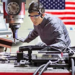 Engineer reviewing a custom tooling fixture used to improve manufacturing repeatability and automation readiness